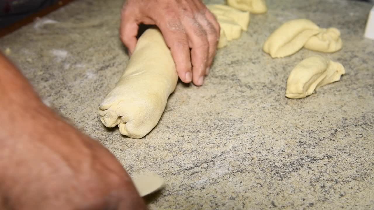 男人们用手把生面团切成块来做意大利panzerotti馅饼视频素材