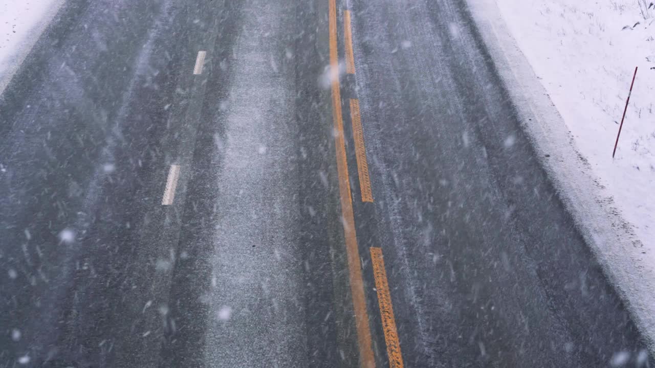 在冬季的一天，在暴风雪中高速公路上的交通使驾驶变得危险。视频素材