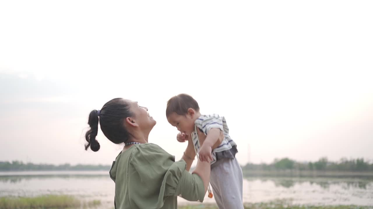 一个女人手里抱着一个小男孩，充满爱意地看着他视频素材