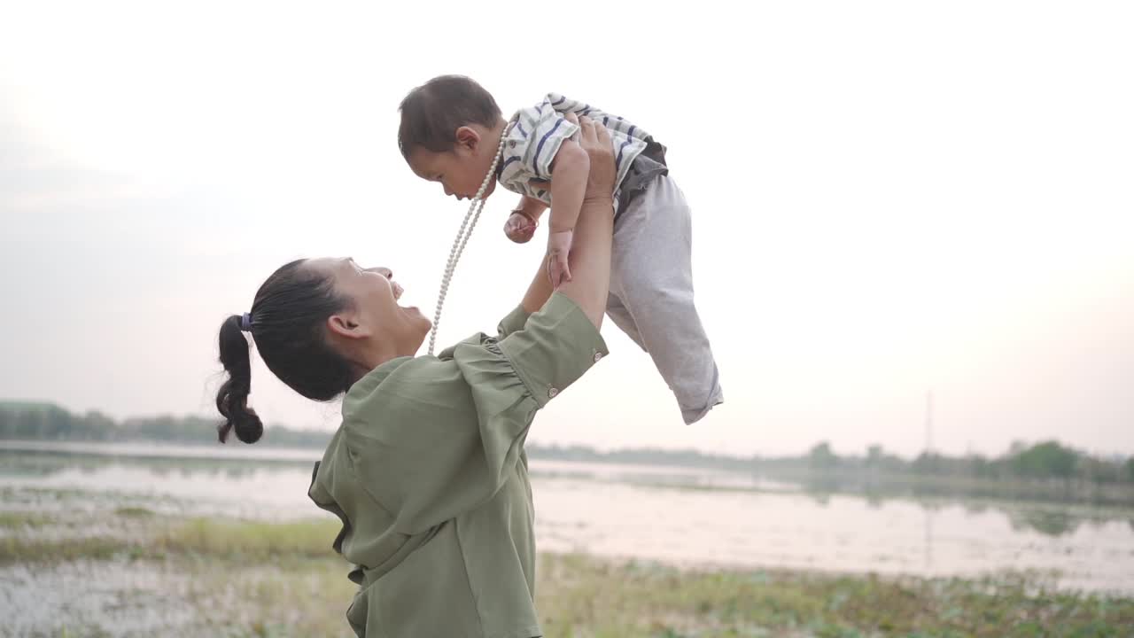 一个女人手里抱着一个小男孩，充满爱意地看着他视频素材