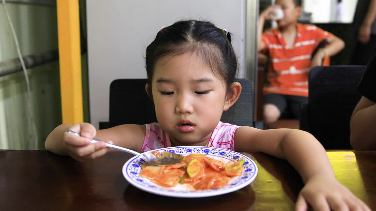 用勺子吃饭的小女孩视频素材