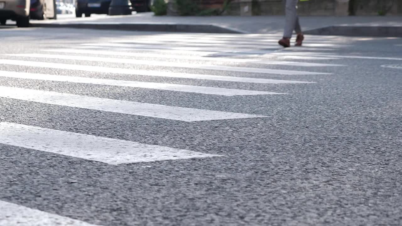 在城市街道上的行人过街。特写镜头在沥青视频素材