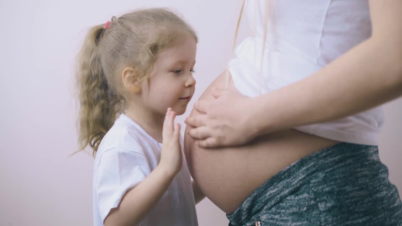 小女孩在家和年轻的怀孕妈妈玩视频素材