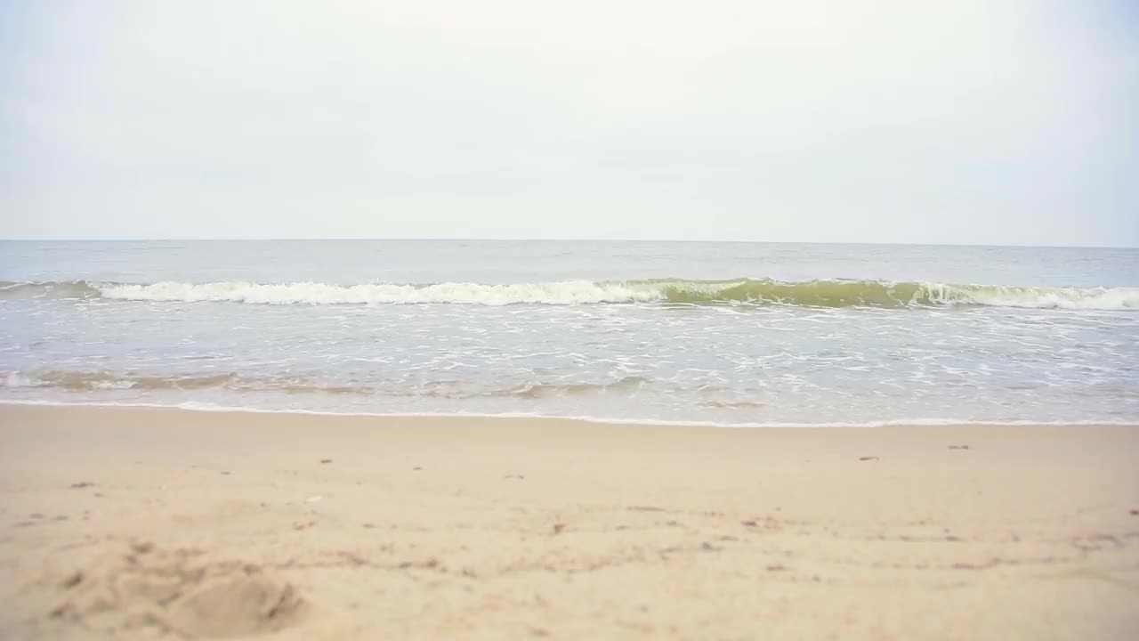 沙滩上的海浪以寒冷的天气为背景视频素材