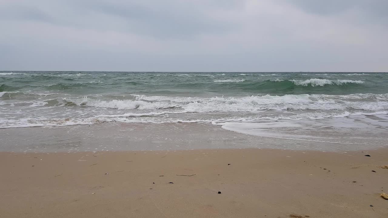 海景，沙滩，大海和灰色的云，海鸥在海浪上翱翔。暴风雨天气。波涛汹涌的海面。视频素材