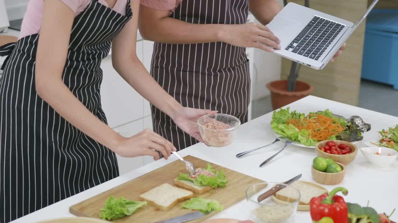 夫妻俩在家里一起在厨房做饭蔬菜沙拉视频素材