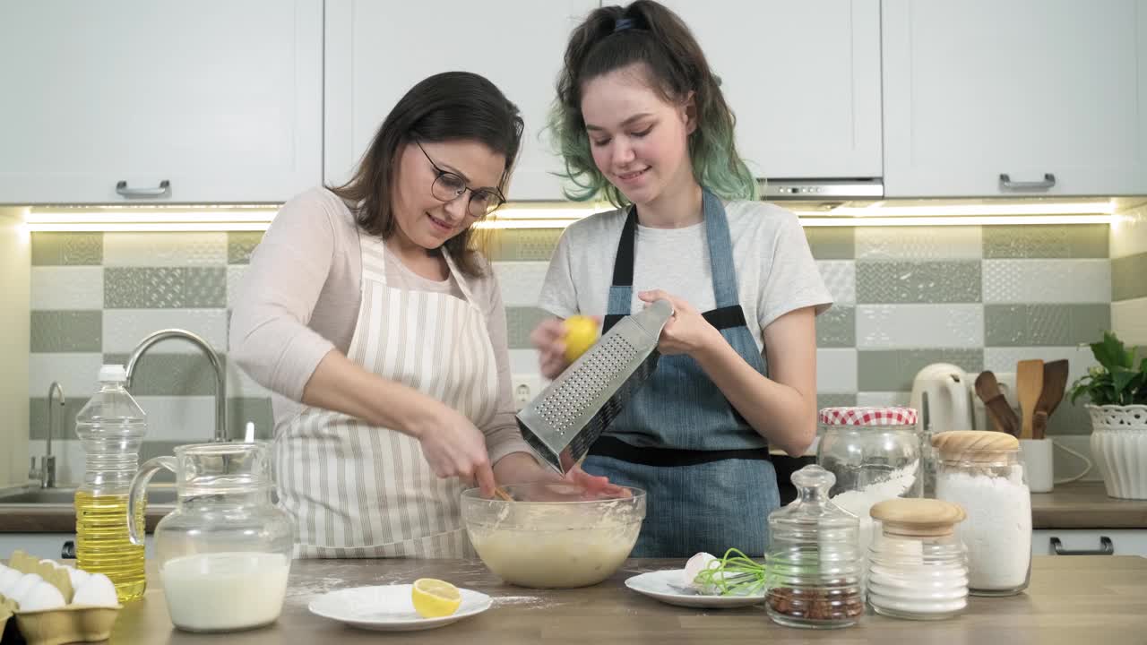 母亲和十几岁的女儿一起在厨房做饭视频素材