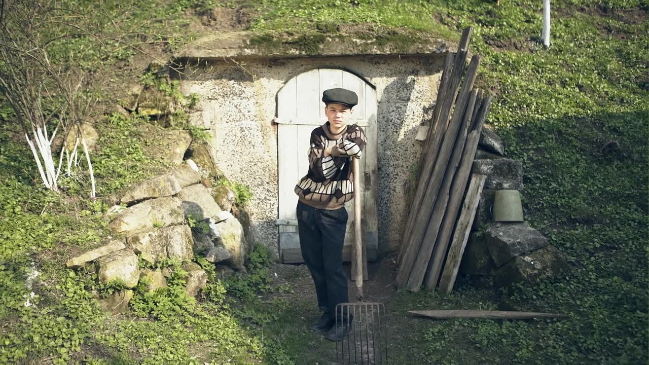可怜的孩子在乡下倚着干草叉视频素材画面4