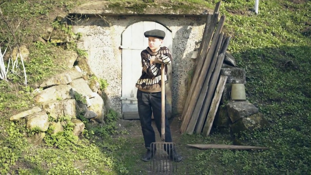 农村男孩站在建在山上的储物坑旁边视频素材画面1