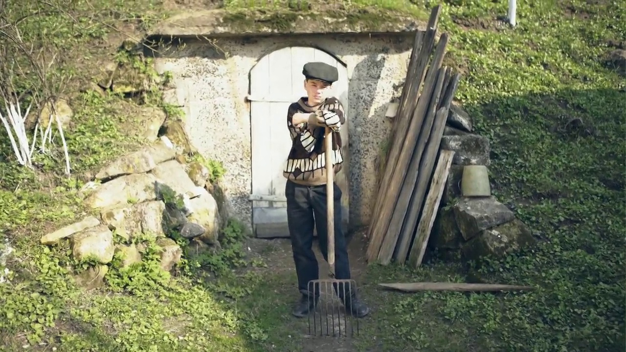 农村男孩站在建在山上的储物坑旁边视频素材画面3
