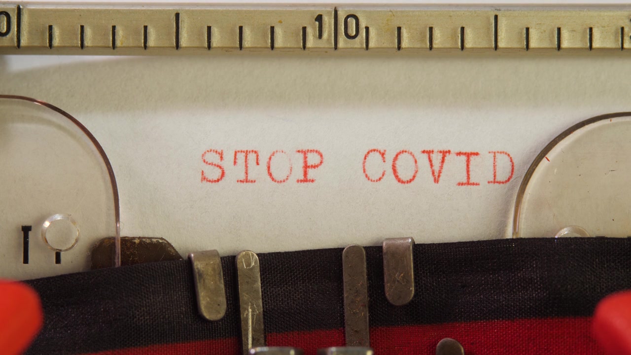 在固定式机械打字机上输入红色文字STOP COVID视频素材画面4