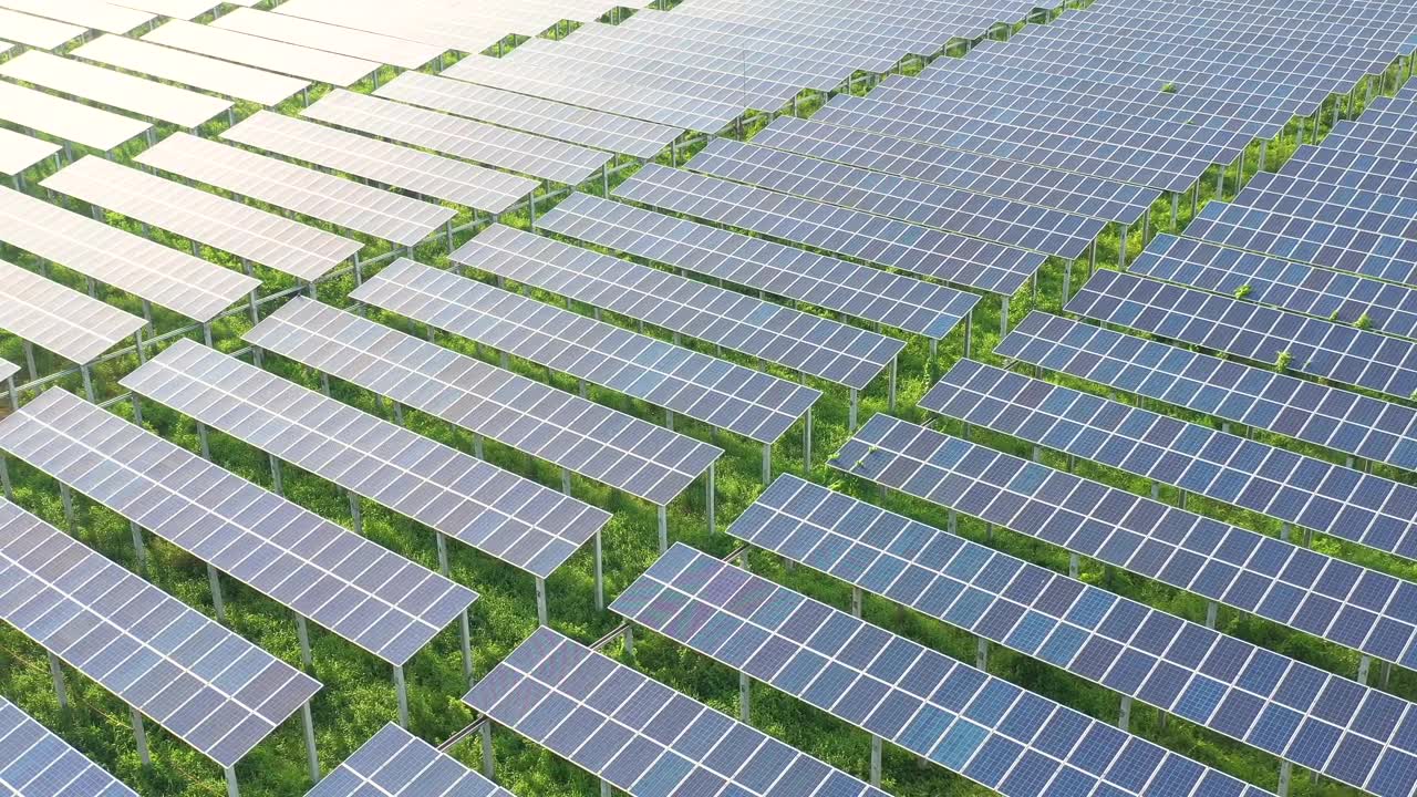 太阳能农场太阳能板反射阳光工业工厂的4K鸟瞰图。视频素材画面1