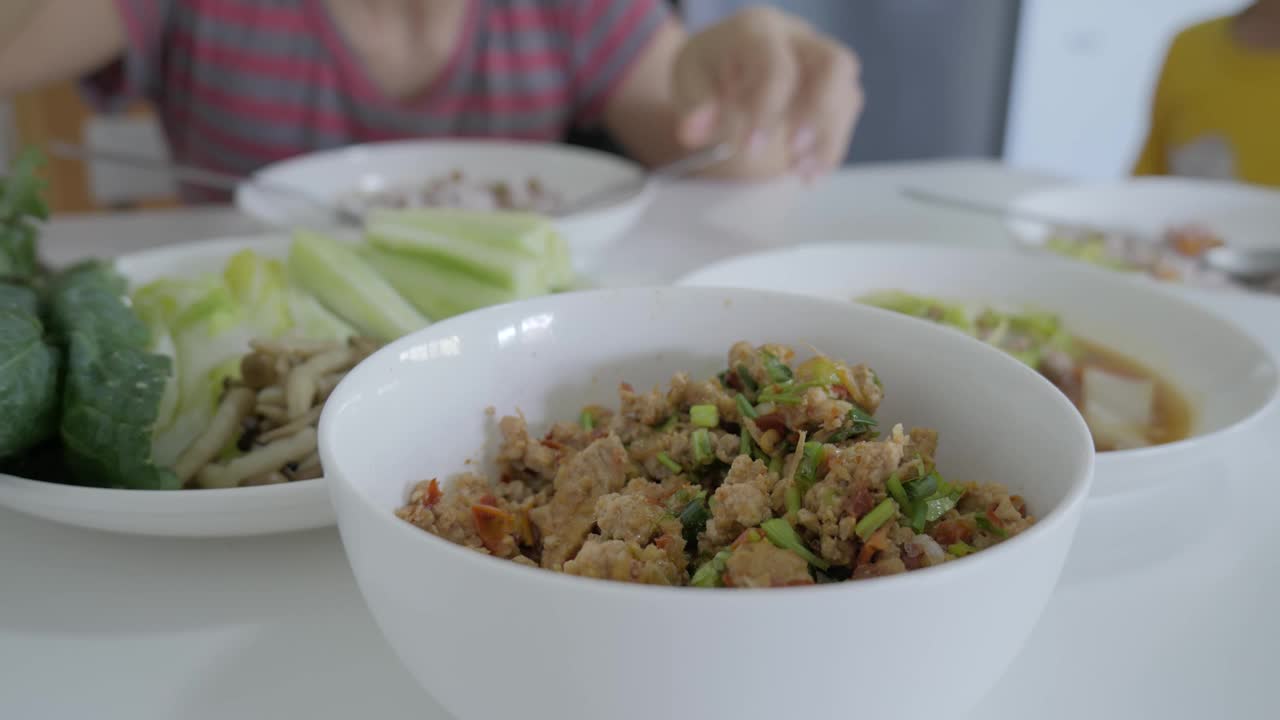 在餐桌上吃传统的泰国菜。视频素材