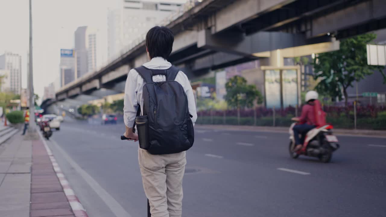 一名男子骑着踏板车在城市街道上行驶视频素材