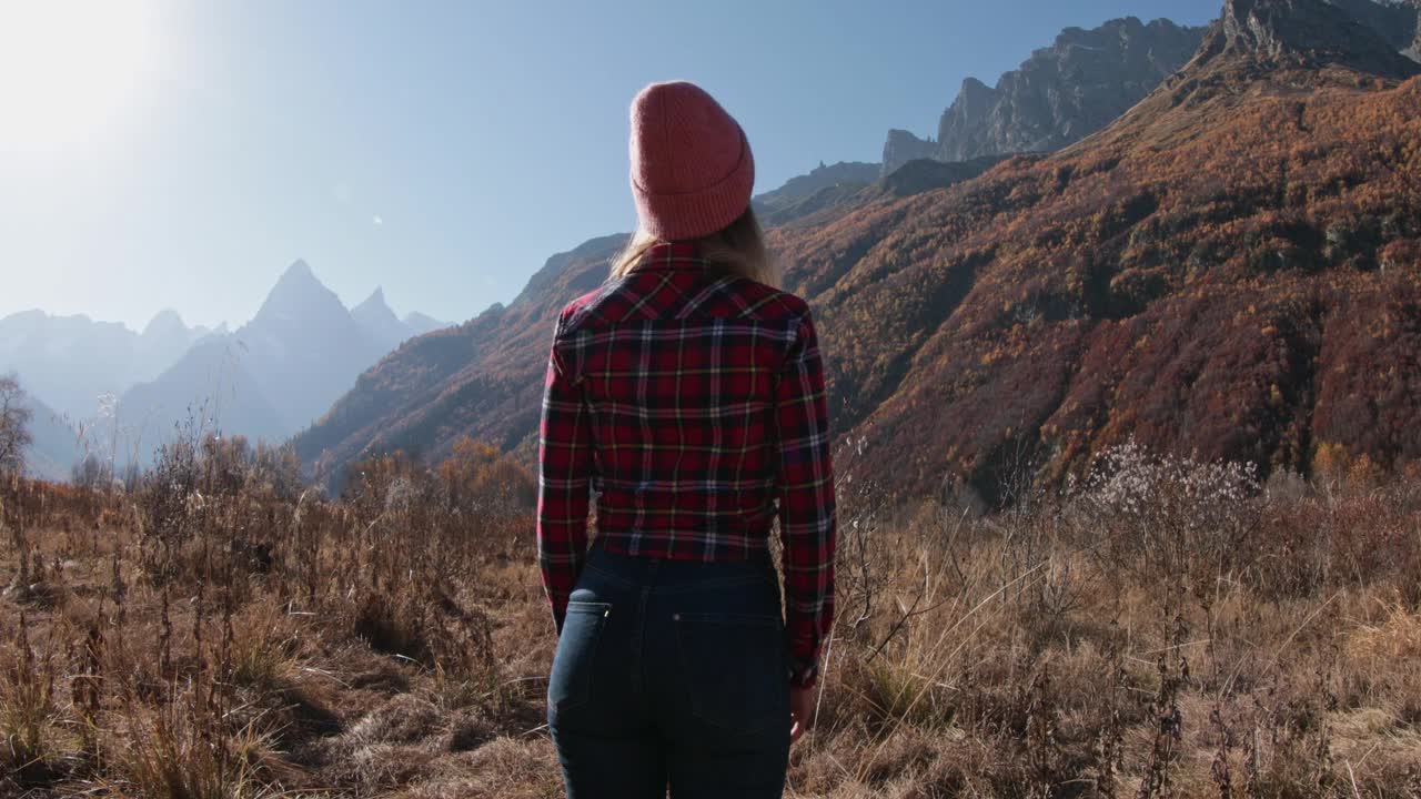 年轻女子在秋天的山上享受。山与快乐游客视频素材