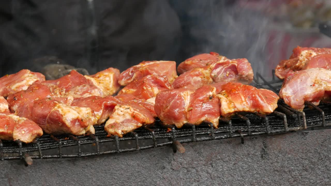 羊肉串。在木炭烤架上煎炸的猪肉或羊肉块。在休息时煎烤肉块。街头食品。美食节。赌注下的猪肉。炒猪肉。视频素材