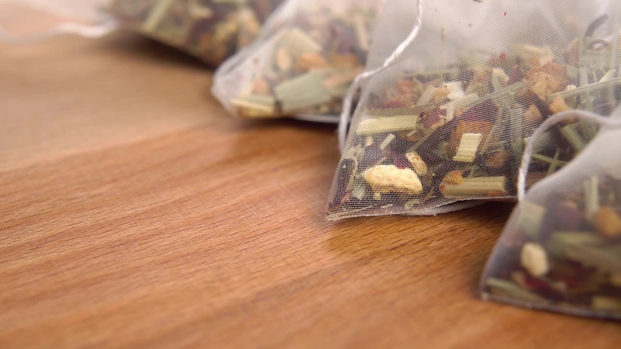 草本茶金字塔袋在木质表面视频素材