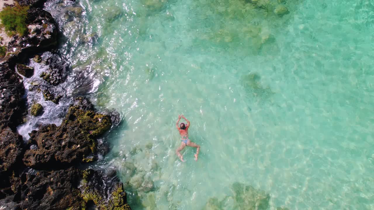 航空自上而下的观点，适合女人游泳在水晶清澈的水。热带海滩浮潜。蓝绿色的海水视频下载