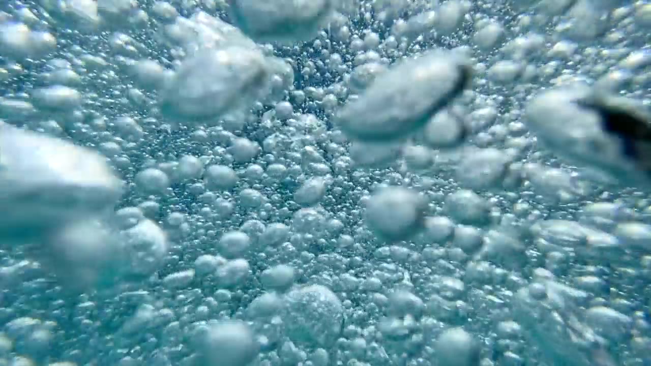 一个十几岁的男孩在一个有泡泡的游泳池里玩耍。——慢动作视频素材画面2