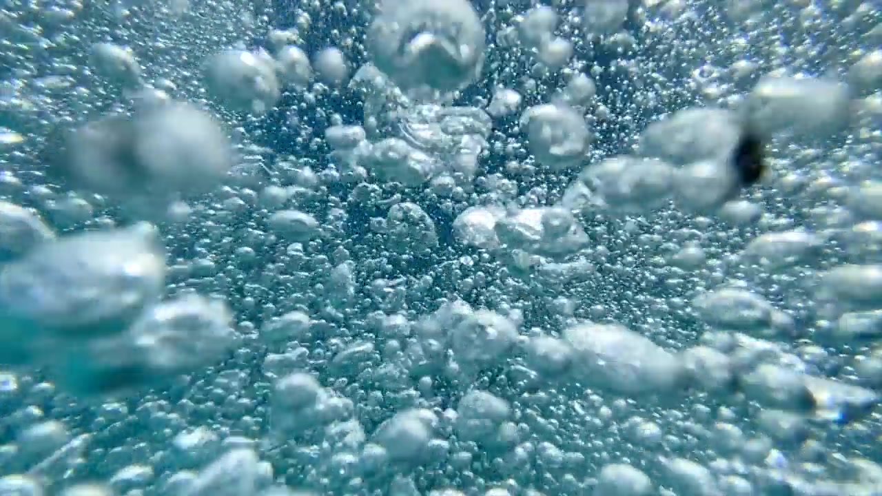 一个十几岁的男孩在一个有泡泡的游泳池里玩耍。——慢动作视频素材画面3