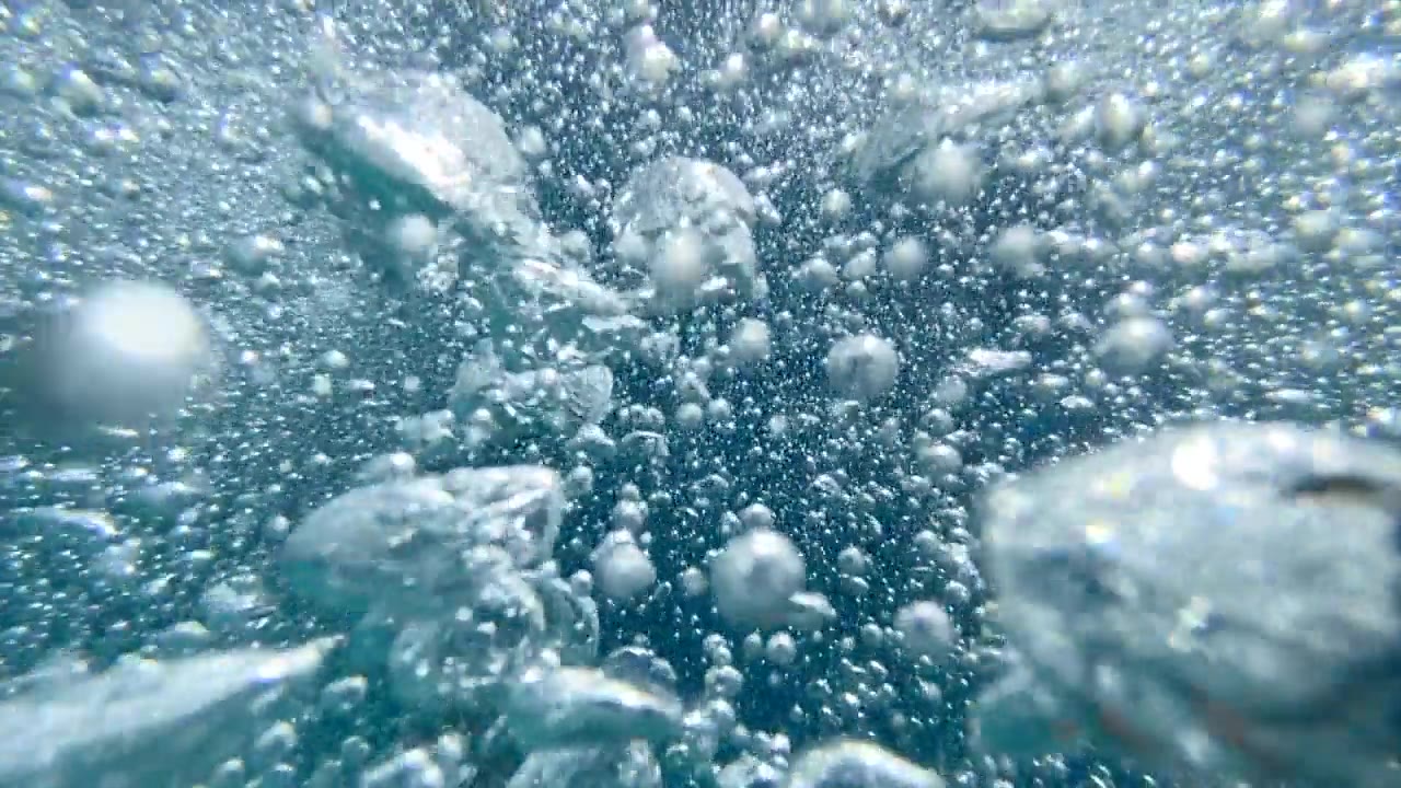 一个十几岁的男孩在一个有泡泡的游泳池里玩耍。——慢动作视频素材画面4