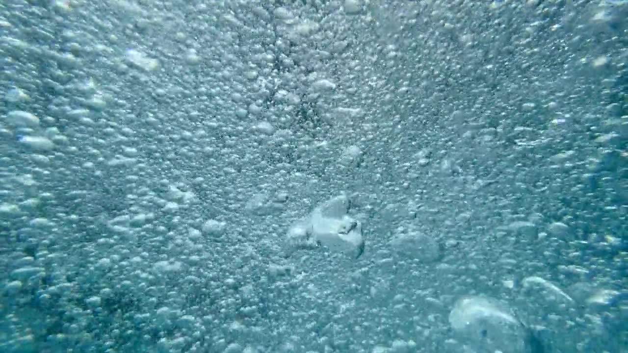 一个十几岁的男孩在一个有泡泡的游泳池里玩耍。——慢动作视频素材画面1