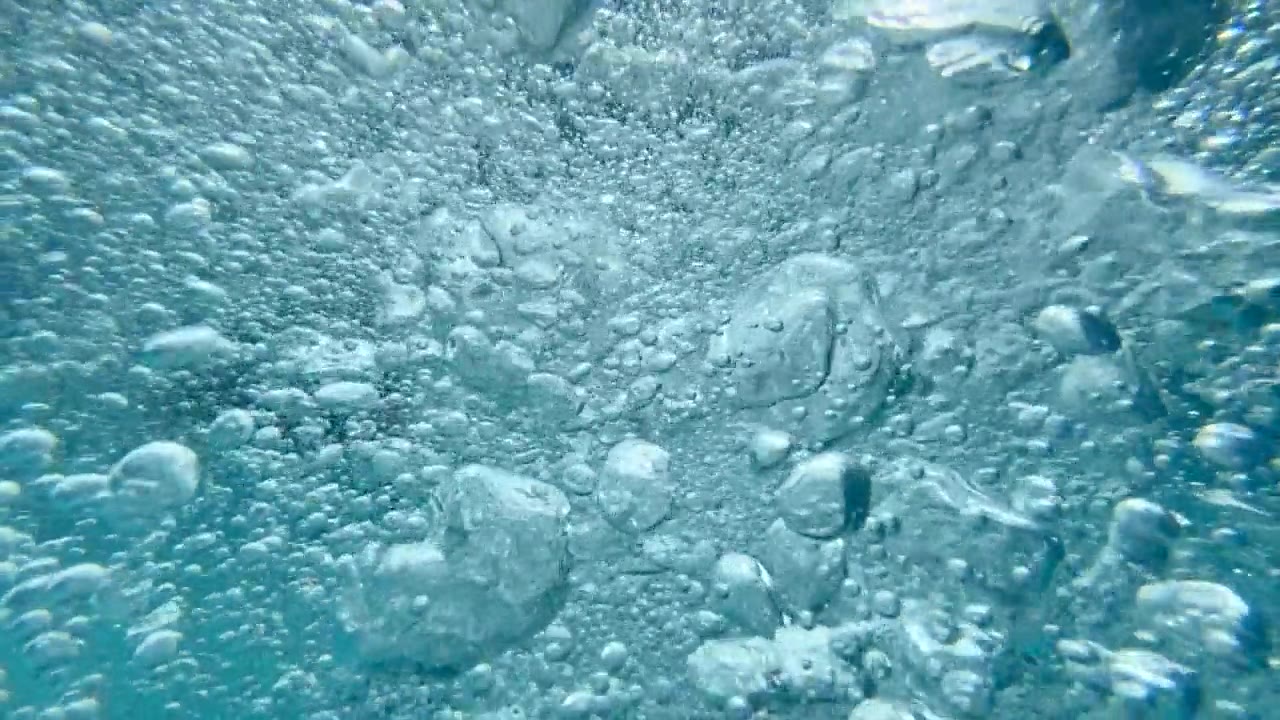 一个十几岁的男孩在一个有泡泡的游泳池里玩耍。——慢动作视频素材画面2