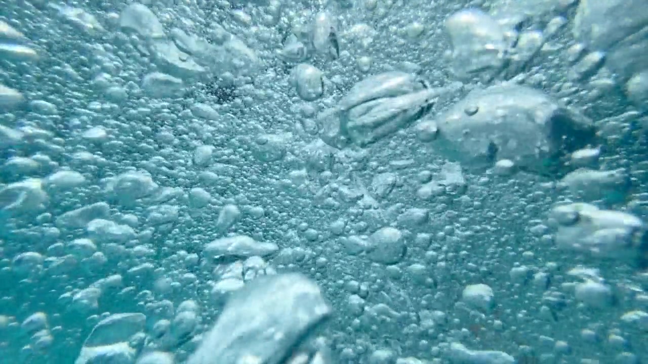 一个十几岁的男孩在一个有泡泡的游泳池里玩耍。——慢动作视频素材画面3