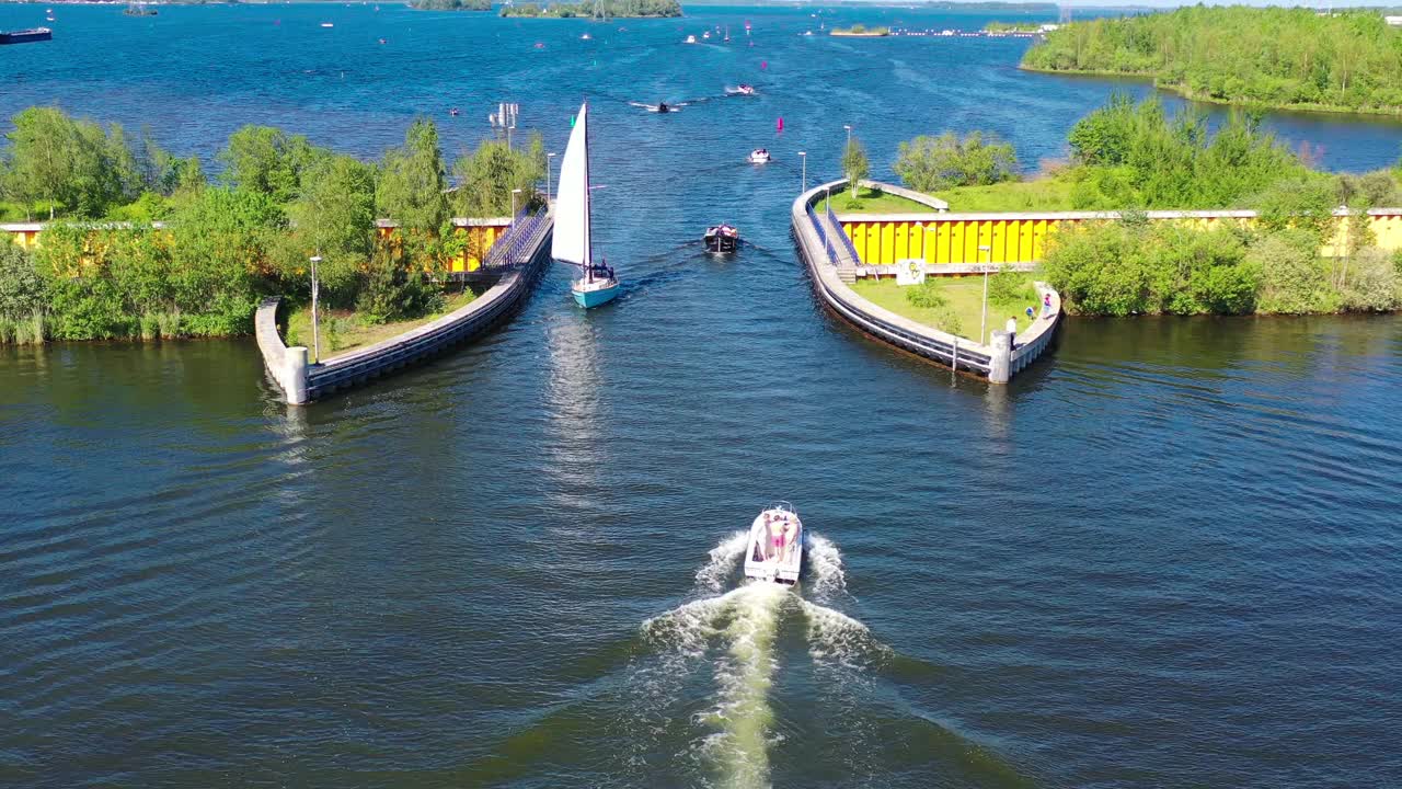 水渠现在Veluwemeer,荷兰。无人机的鸟瞰图。一艘帆船驶过高速公路上方湖面上的渡槽视频素材