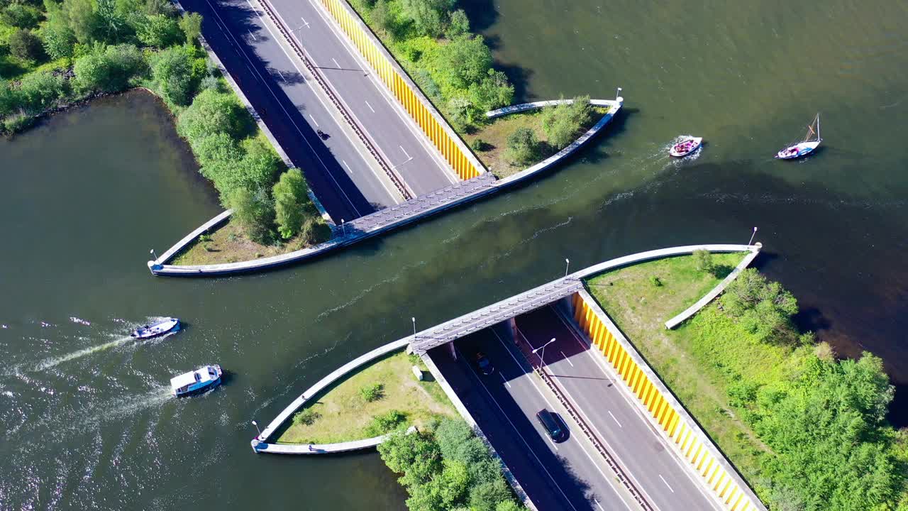 水渠现在Veluwemeer,荷兰。无人机的鸟瞰图。一艘帆船驶过高速公路上方湖面上的渡槽视频素材