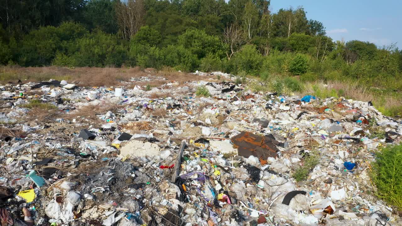 在垃圾填埋场飞过成堆的塑料垃圾和生活垃圾视频素材