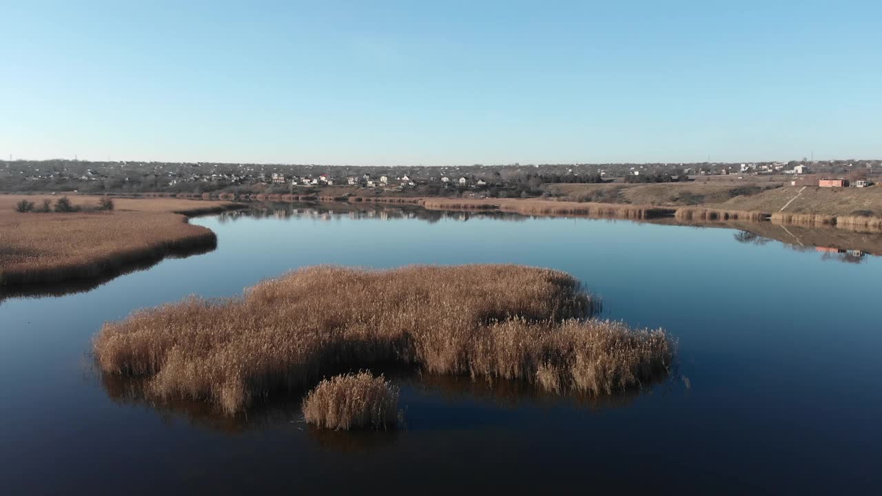 在河口上空缓慢飞行的无人机。水里有干草视频素材