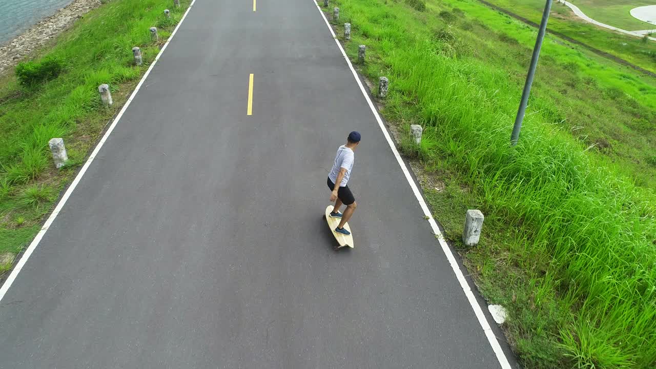 在水坝路上玩冲浪板的人视频下载