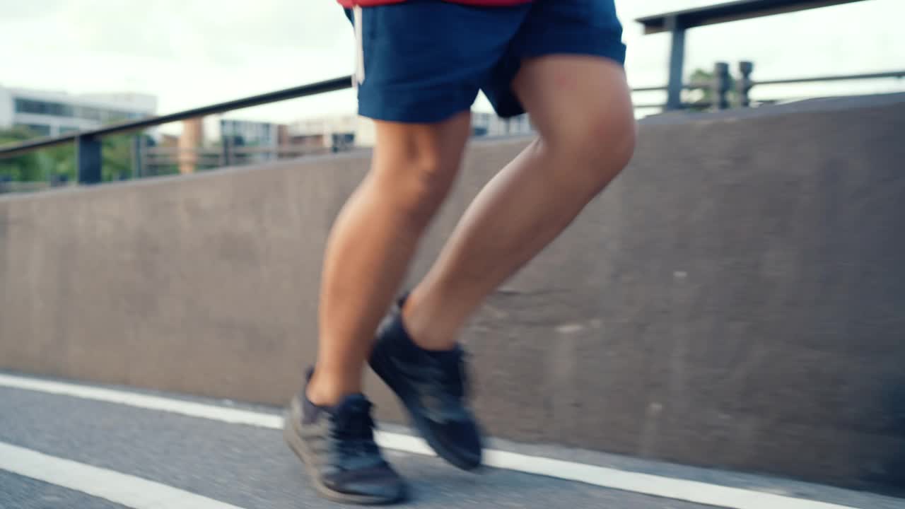 一个活跃的男人沿着城市的道路奔跑。视频素材