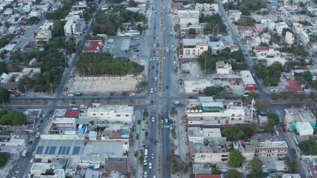 在墨西哥图卢姆(Tulum)的城市街道上，车辆被建筑和房屋包围，向森林、海洋和晴朗的天空延伸视频素材