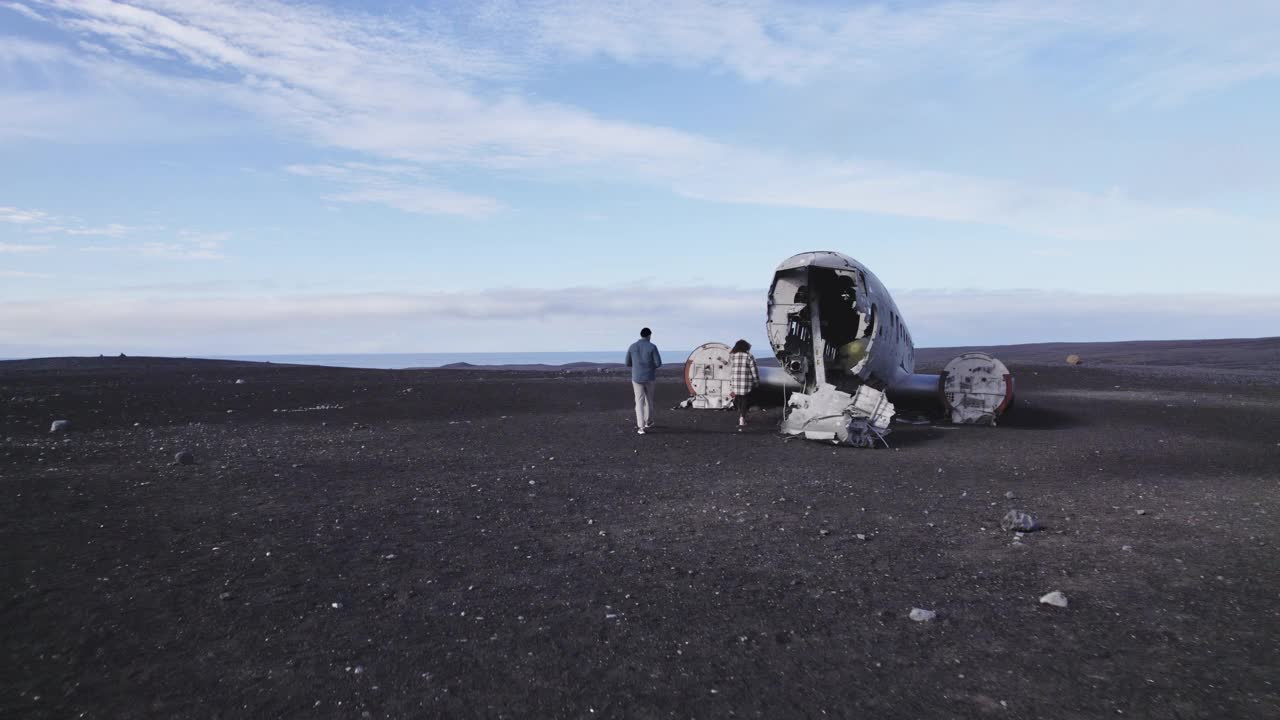 旅客在Solheimasandur失事飞机上对相机摆姿势的航拍视频素材