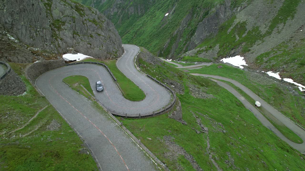 无人机:灰色旅游车行驶在帕索圣戈塔多的曲折道路上。视频素材