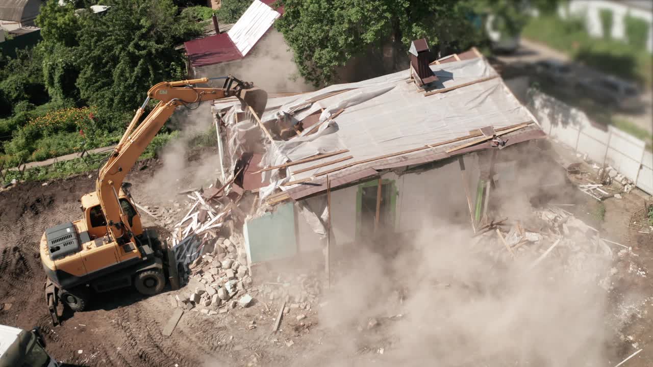 拆除旧房屋建造工艺为新建筑采用挖掘机铲斗，鸟瞰图。城市发展视频素材