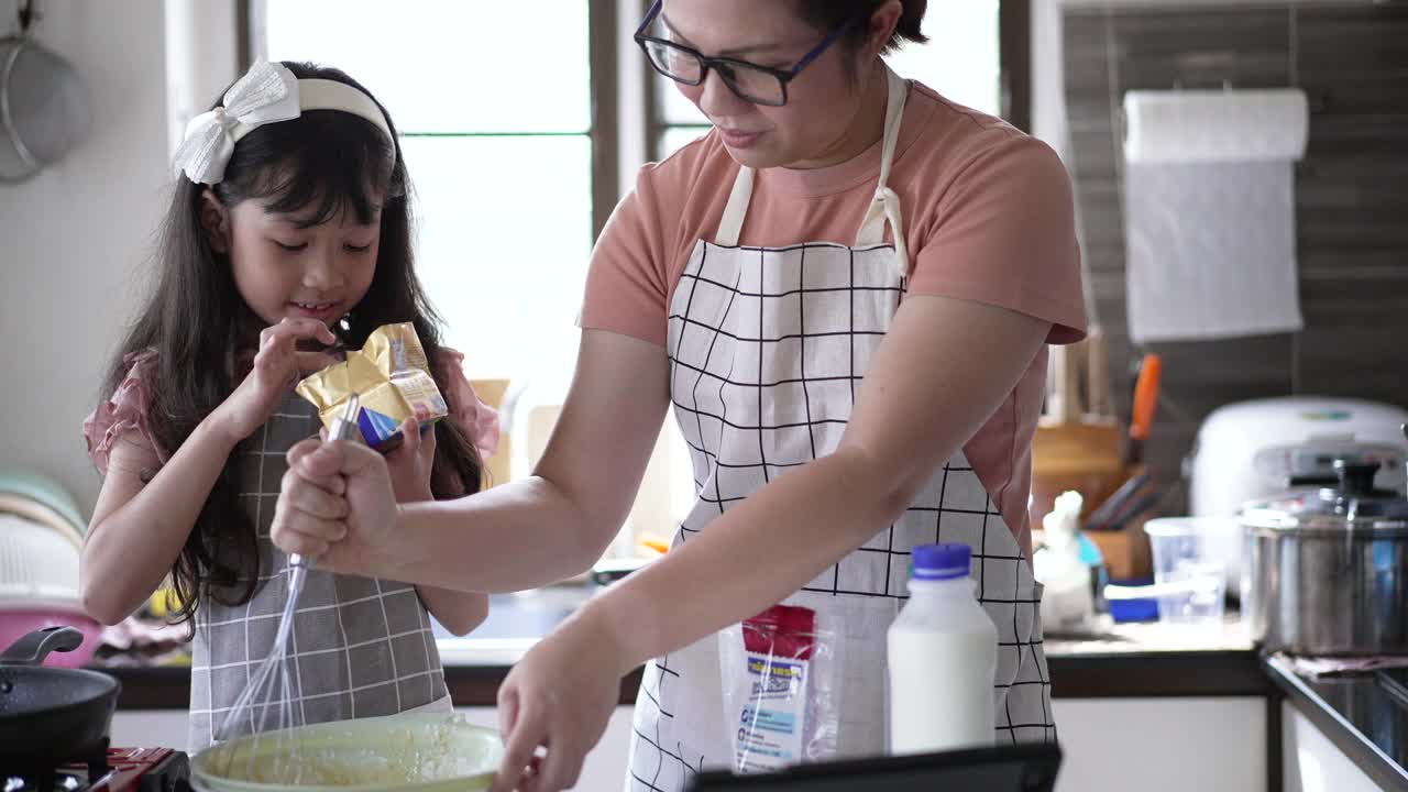 妈妈在厨房教女儿做煎饼视频素材