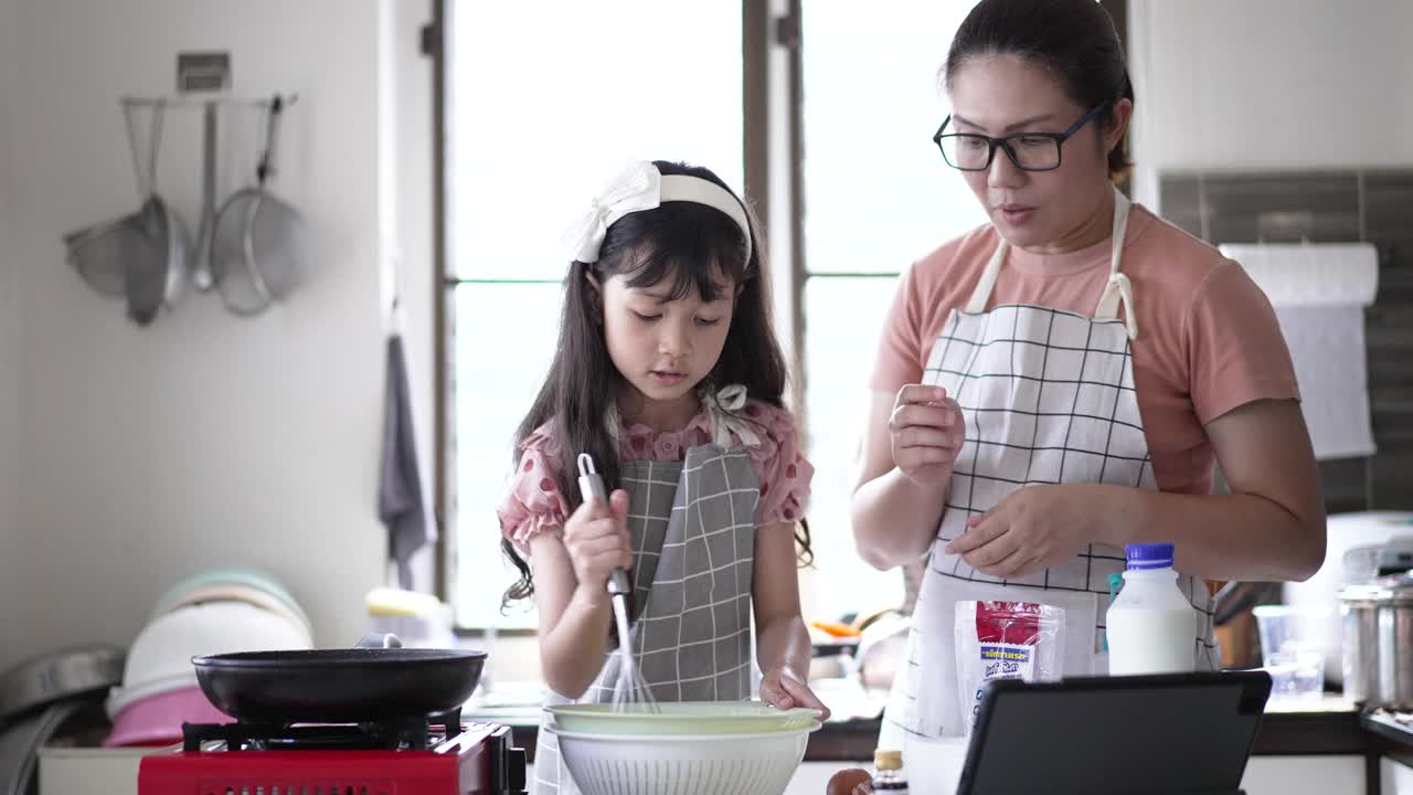 妈妈在厨房教女儿做煎饼视频素材