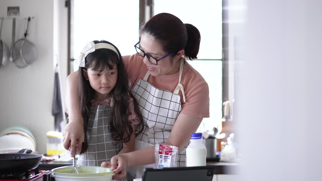 妈妈在厨房教女儿做煎饼视频素材