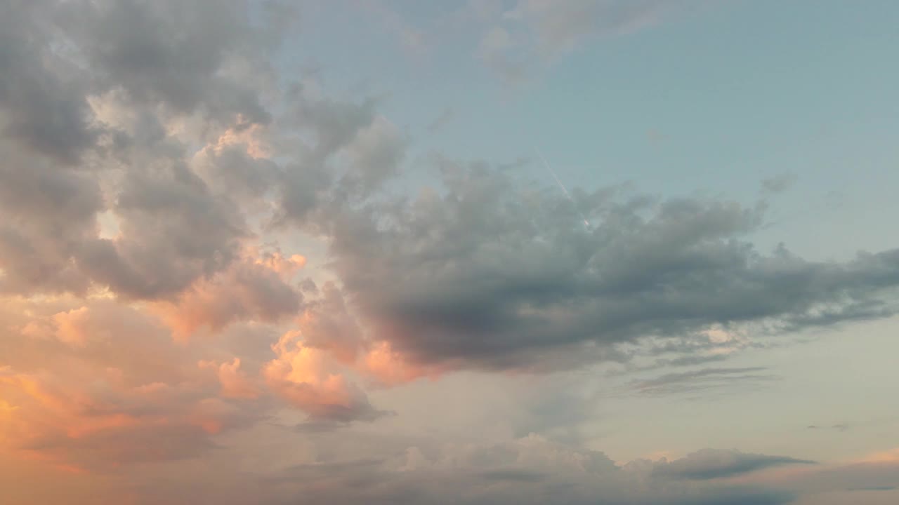 蓝色的傍晚天空和阳光下的红色云朵的动态全景。视频素材