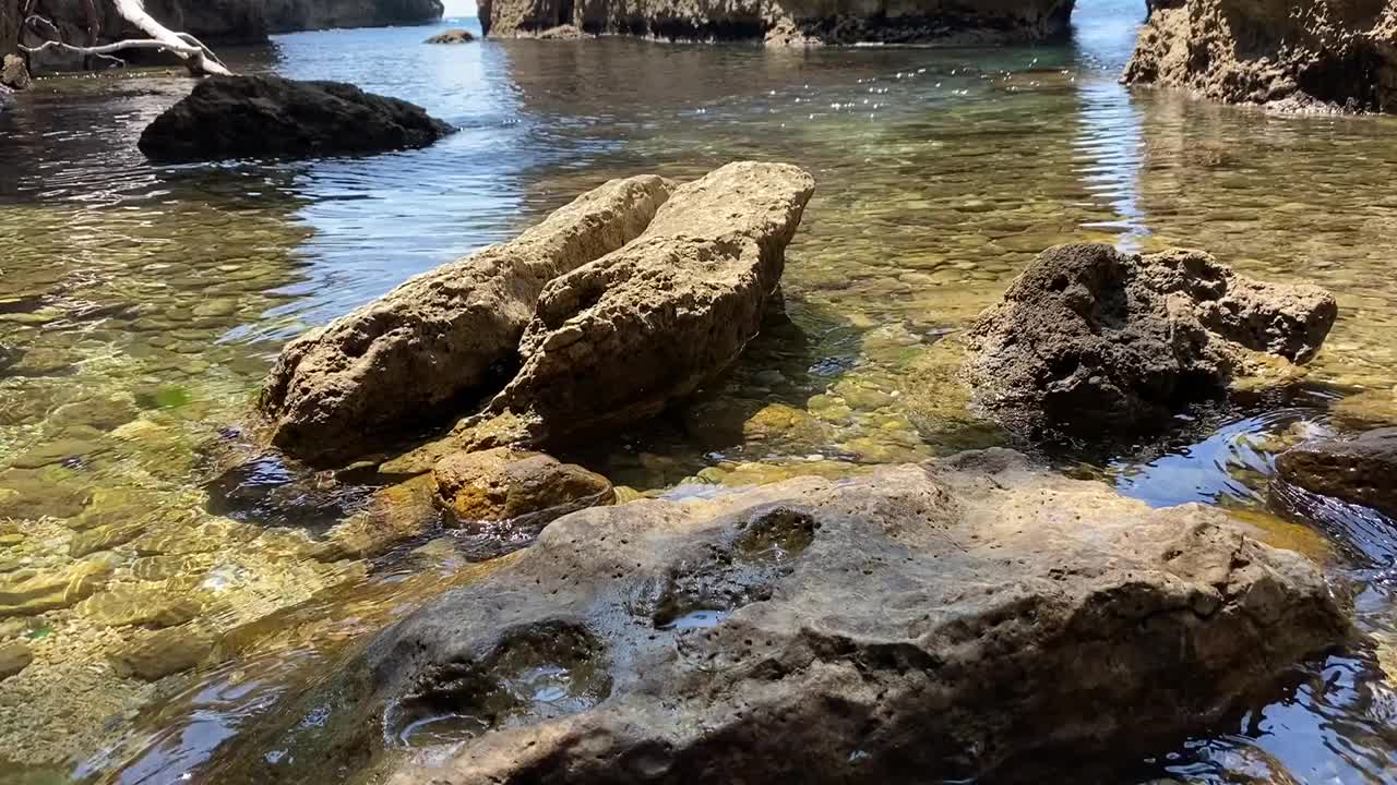 海水清澈，岩石峡谷。光滑的鹅卵石和风景优美的石头和砾石在干净闪亮的泉水。地中海海岸令人惊叹的自然风光。宁静，禅，放松，安静。视频素材