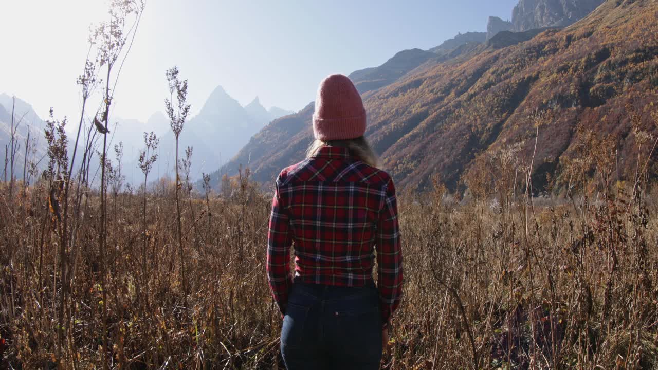 旅行者女人漫步在秋天的山上。山和旅游视频素材