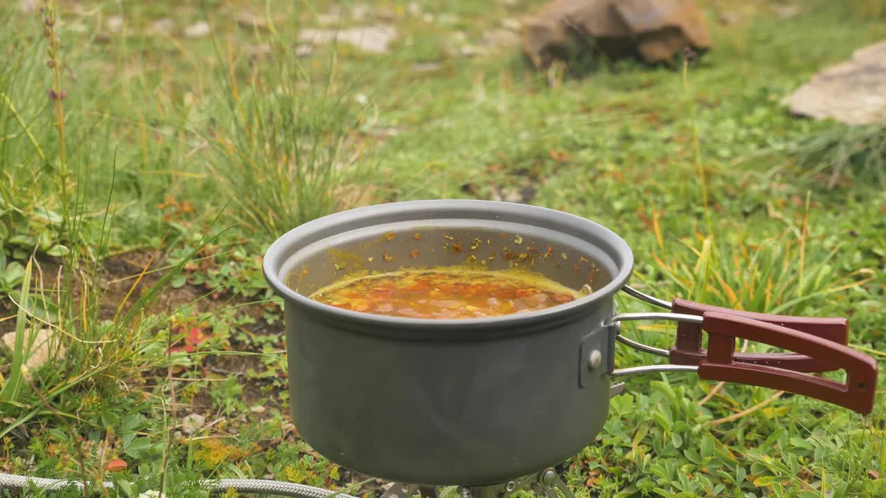 在煤气灶上的野炊锅里煮汤视频素材