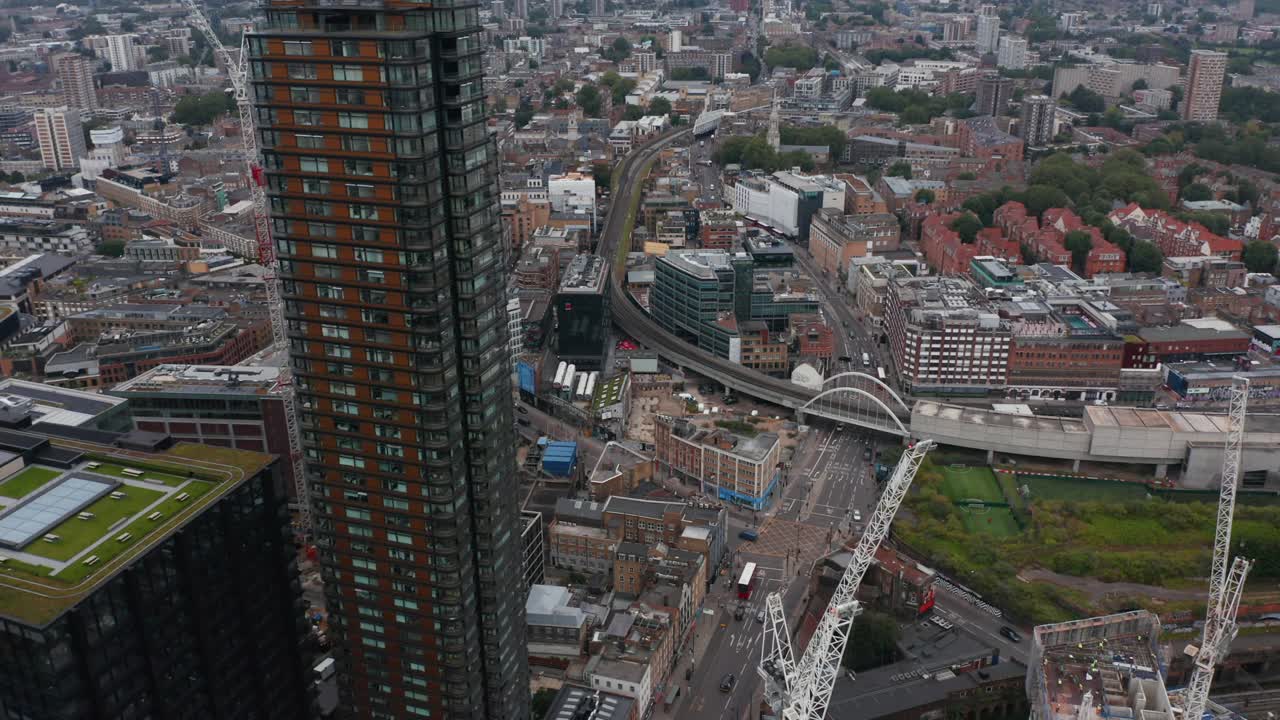 向前飞在城市上空。在十字路口和铁路桥上倾斜。道路上行驶的车辆。英国伦敦视频素材