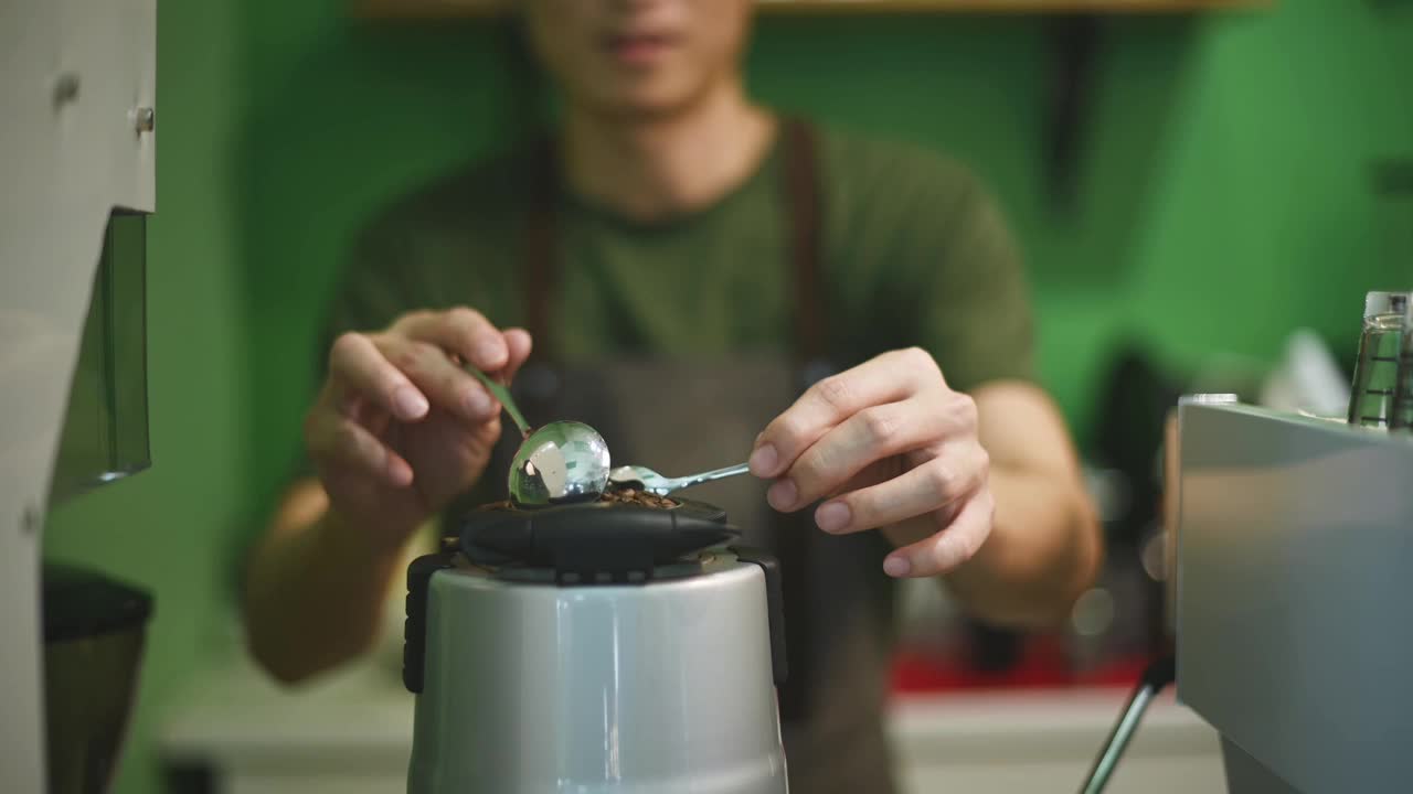 亚洲华人男咖啡师舀入咖啡研磨机与烘培咖啡豆准备咖啡研磨浓缩咖啡在咖啡店视频素材