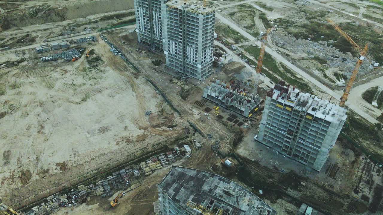 一个现代化城市街区的建筑工地。正在建设中的高层建筑。建筑塔式起重机。日落时的航空摄影。视频素材