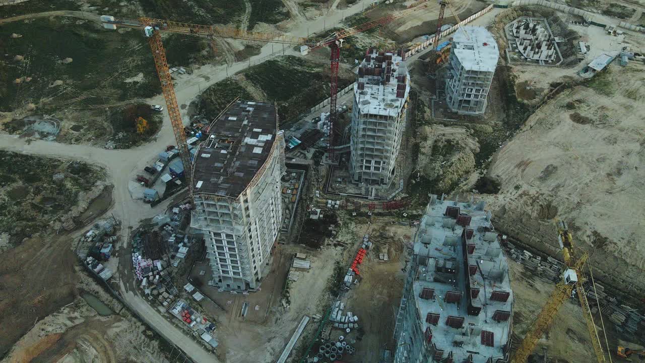 一个现代化城市街区的建筑工地。正在建设中的高层建筑。建筑塔式起重机。日落时的航空摄影。视频素材