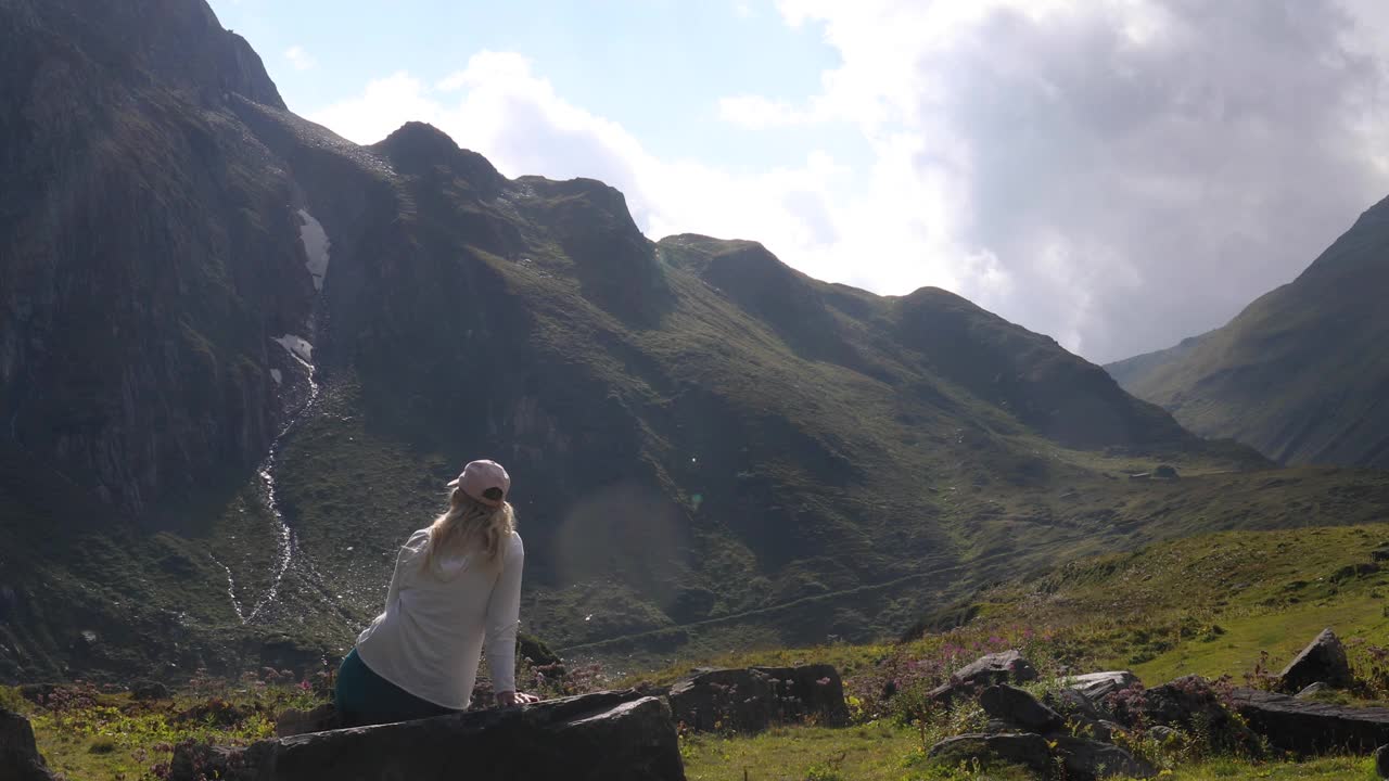 女徒步旅行者在山间草地上放松视频素材